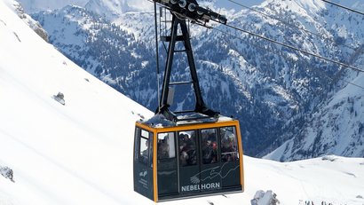 Seilbahn mit Passagieren im verschneiten Nebelhorn-Gebirge